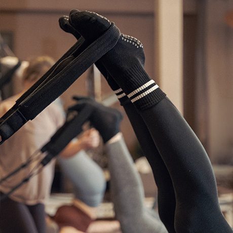 Voeten in gripsokken op de footbar tijdens een reformer pilates les bij Reform040 Eindhoven