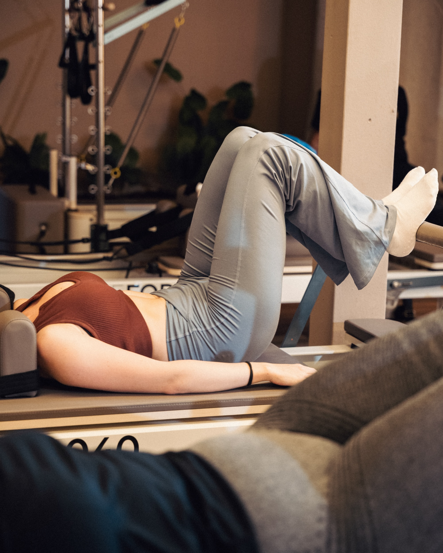Vrouw op de reformer tijdens een rustige pilates oefening bij Reform040 in Eindhoven